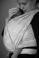 Egy újszülött édesanyja mellkasán hordozókendőben: C alakú gerinccel, felhúzott, térdben behajlított lábakkal