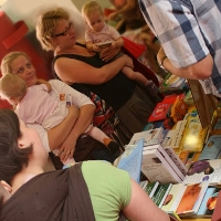 A képen könyveket válogató szülők gyerekeikkel. Kattintásra ugrás az ajánlott olvasmányokra.